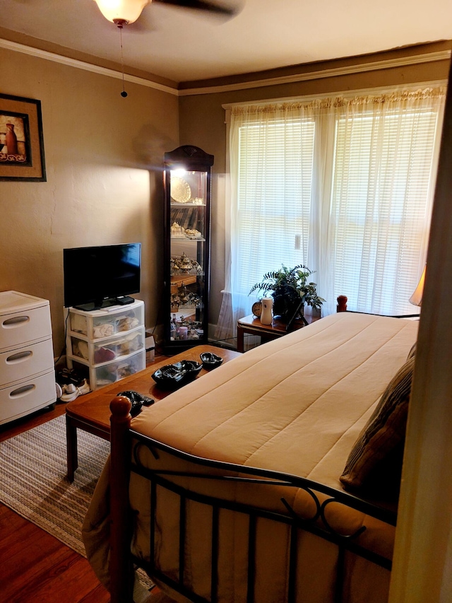 bedroom with crown molding, hardwood / wood-style floors, and ceiling fan