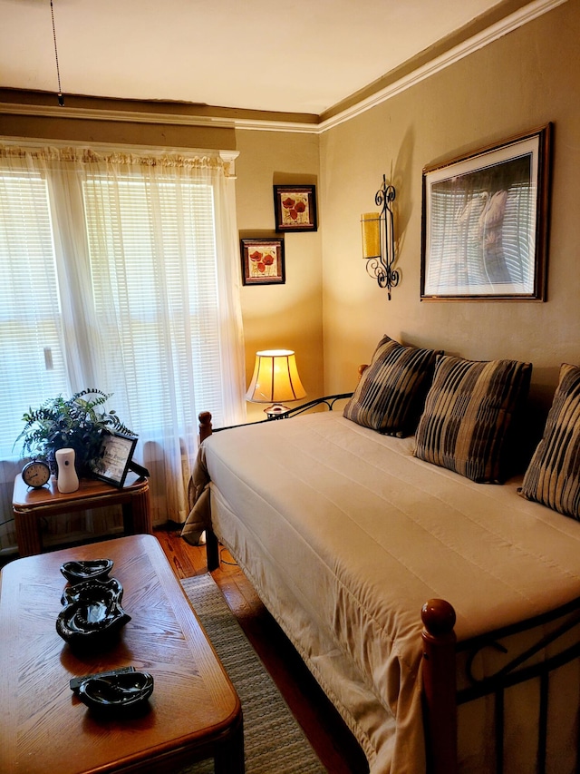 bedroom with hardwood / wood-style floors and crown molding