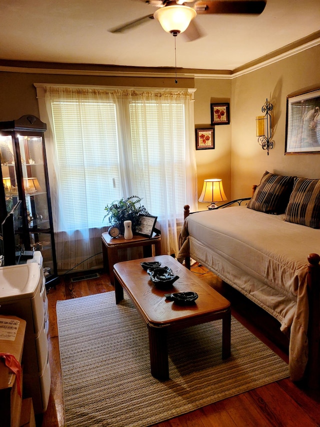 bedroom featuring ornamental molding, dark hardwood / wood-style flooring, and ceiling fan