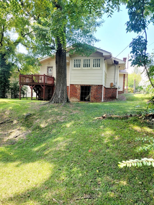 rear view of property with a wooden deck and a lawn