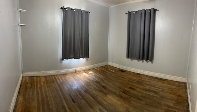 empty room featuring ornamental molding and dark hardwood / wood-style floors