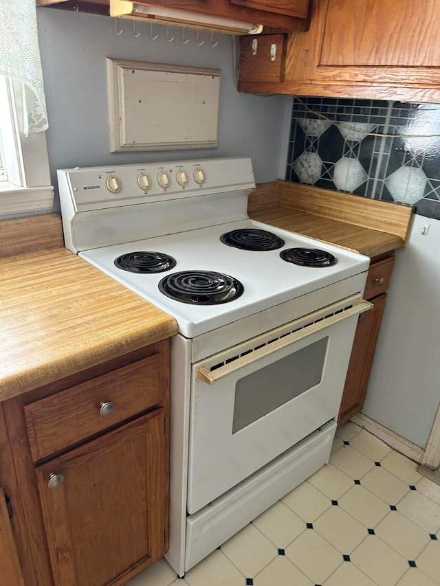 kitchen with white electric range and decorative backsplash