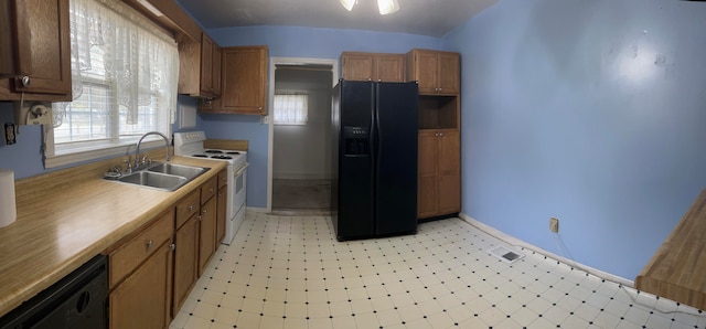 kitchen with black appliances, sink, plenty of natural light, and vaulted ceiling