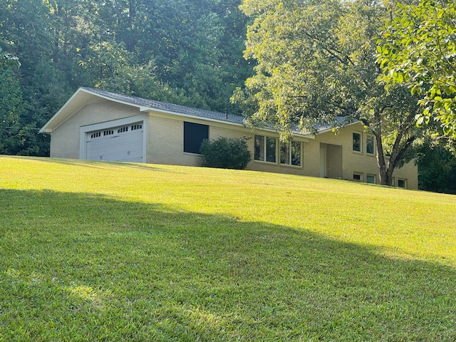 ranch-style house featuring a garage and a front yard