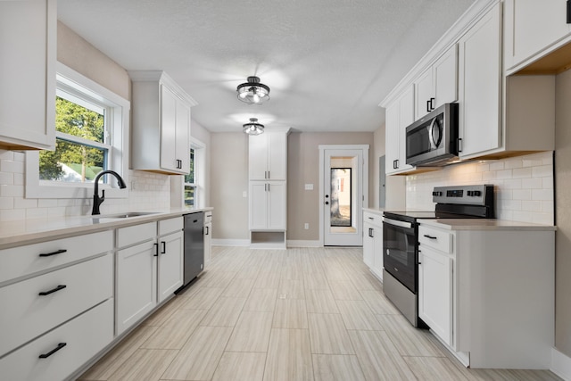 kitchen featuring white cabinets, appliances with stainless steel finishes, and sink