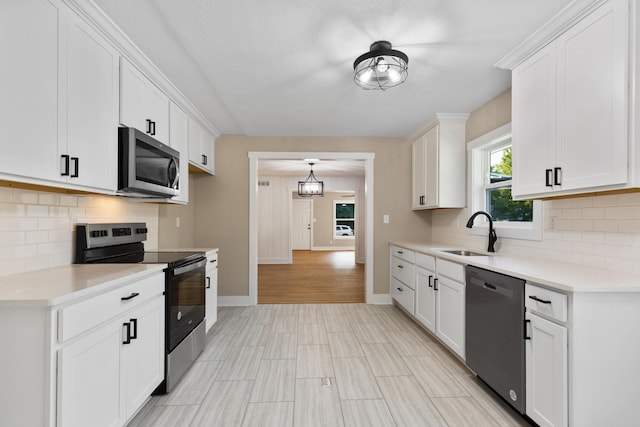 kitchen with white cabinets, appliances with stainless steel finishes, sink, and tasteful backsplash