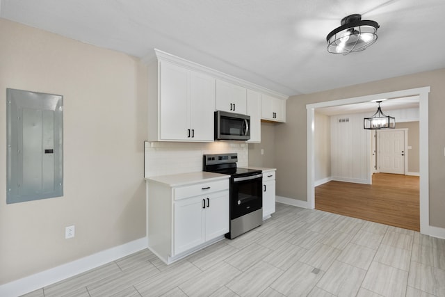 kitchen featuring light hardwood / wood-style floors, electric panel, tasteful backsplash, white cabinets, and stainless steel appliances