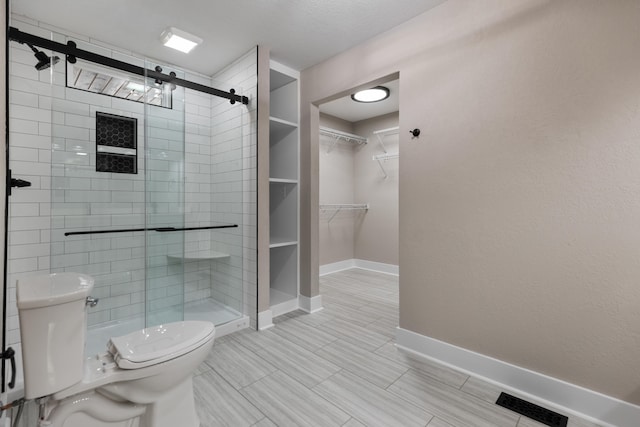 bathroom featuring toilet and an enclosed shower