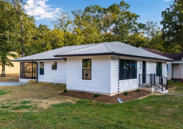 view of front facade featuring a sunroom and a front yard