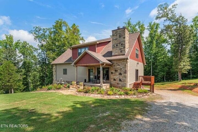 view of front facade with stone siding, a chimney, and a front yard