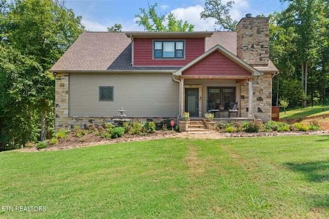 craftsman-style house with a porch, stone siding, a chimney, and a front lawn