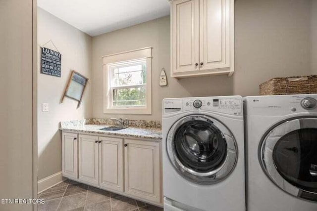 clothes washing area featuring a sink, baseboards, light tile patterned flooring, cabinet space, and separate washer and dryer