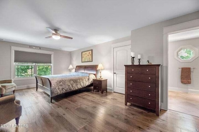 bedroom with a ceiling fan, baseboards, and wood finished floors