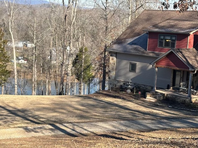 view of side of property featuring roof with shingles