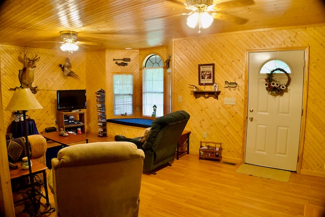 living room with wood ceiling, light hardwood / wood-style flooring, ceiling fan, and wooden walls