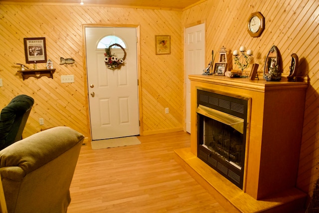 interior space with ornamental molding, wooden walls, and light hardwood / wood-style floors