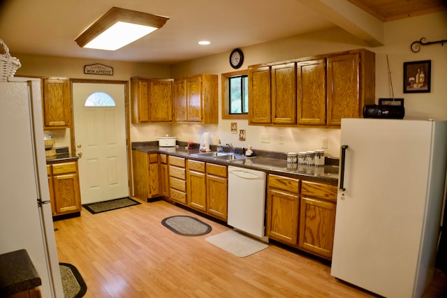 kitchen with white appliances, sink, and light hardwood / wood-style floors