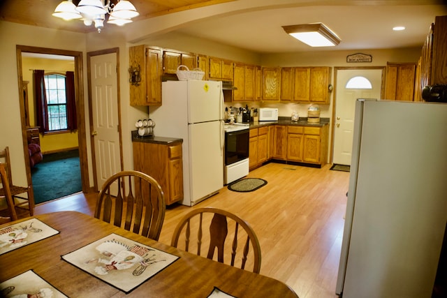 kitchen with beamed ceiling, white appliances, and light hardwood / wood-style floors