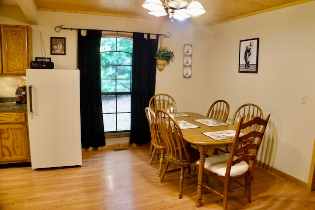 dining area featuring light wood-type flooring, a chandelier, and ornamental molding