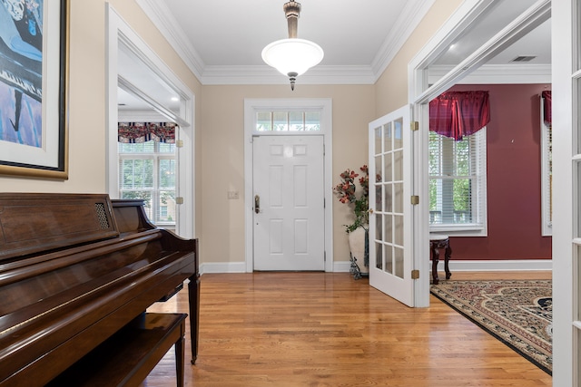 foyer entrance with light hardwood / wood-style floors and crown molding