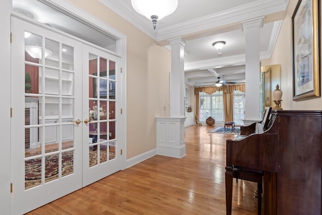 hallway featuring ornamental molding, french doors, hardwood / wood-style floors, and decorative columns