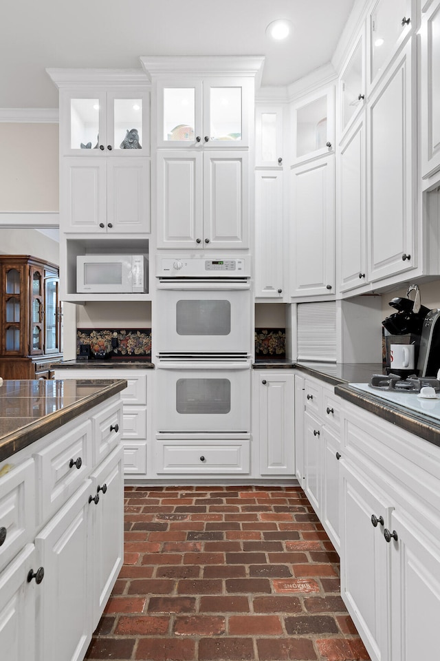 kitchen with white cabinets, white appliances, and crown molding