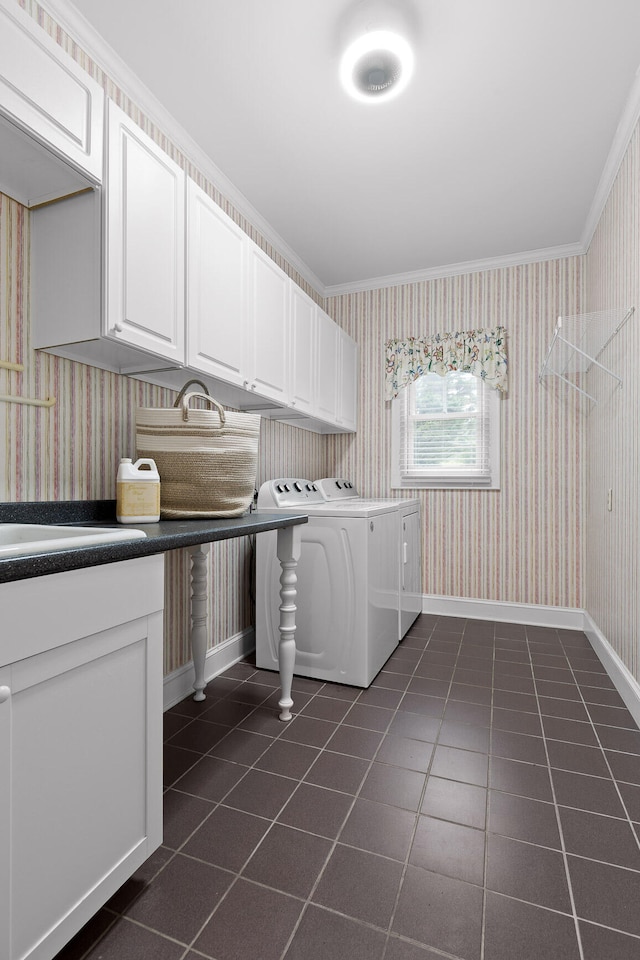 clothes washing area featuring crown molding, cabinets, independent washer and dryer, and dark tile patterned floors