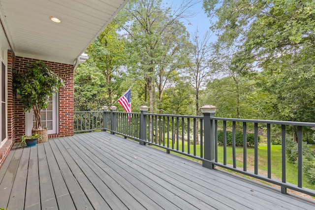 wooden terrace featuring a lawn