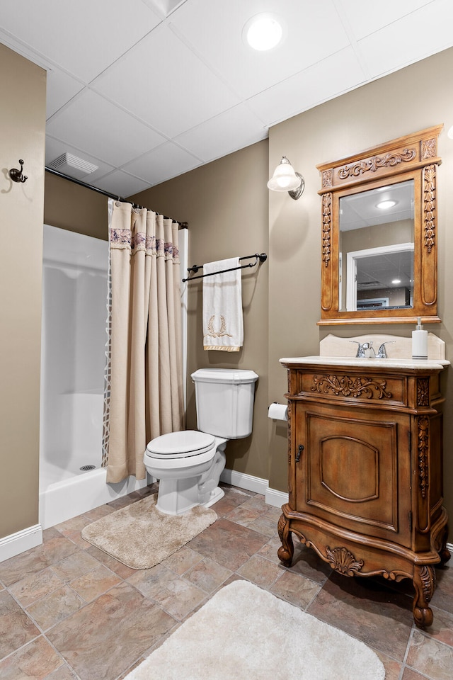 bathroom featuring a shower with curtain, toilet, a drop ceiling, and vanity