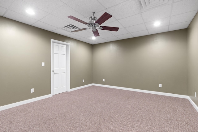 carpeted spare room featuring ceiling fan and a drop ceiling