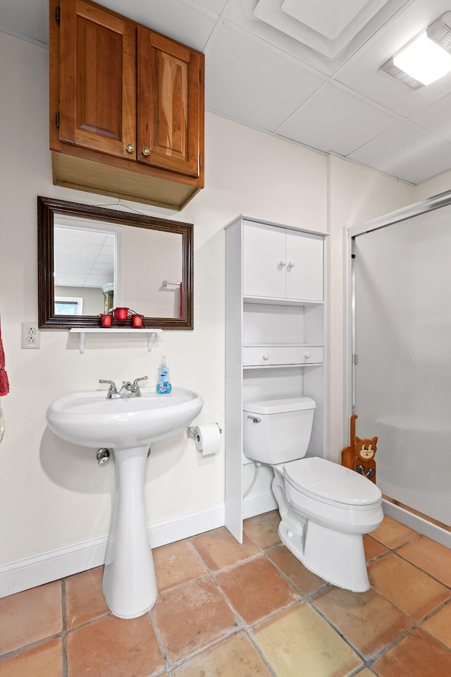 bathroom with tile patterned flooring, a shower with shower door, and toilet