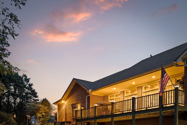 back house at dusk with a wooden deck