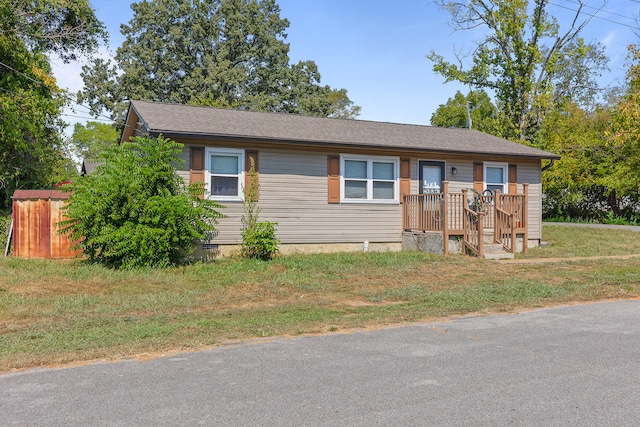 view of front of property featuring a front yard and a wooden deck