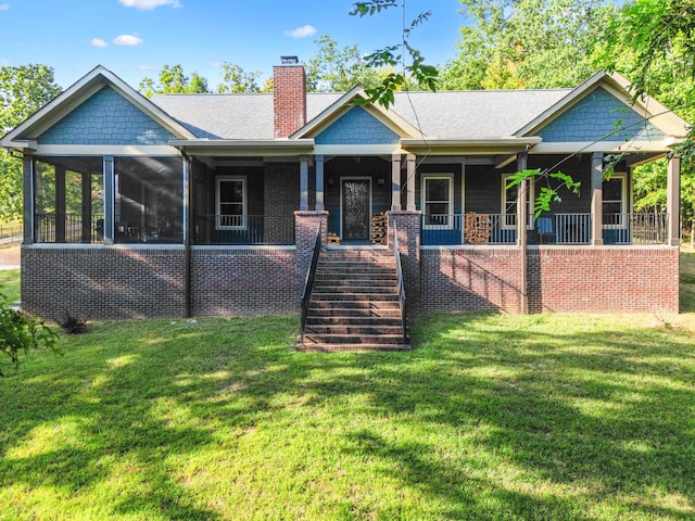 craftsman-style house with a front lawn, covered porch, and a sunroom