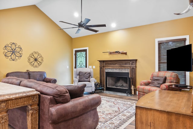 living room with light hardwood / wood-style flooring, ceiling fan, and vaulted ceiling