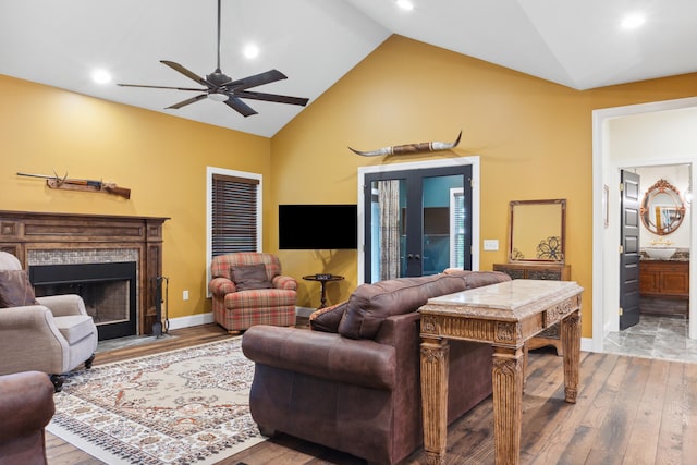 living room with ceiling fan, hardwood / wood-style flooring, and vaulted ceiling