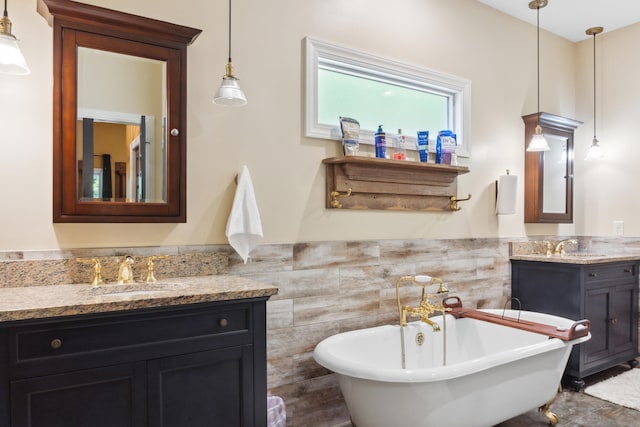 bathroom with vanity, a bathtub, and tile walls