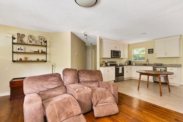 living room with dark hardwood / wood-style flooring, a textured ceiling, and sink