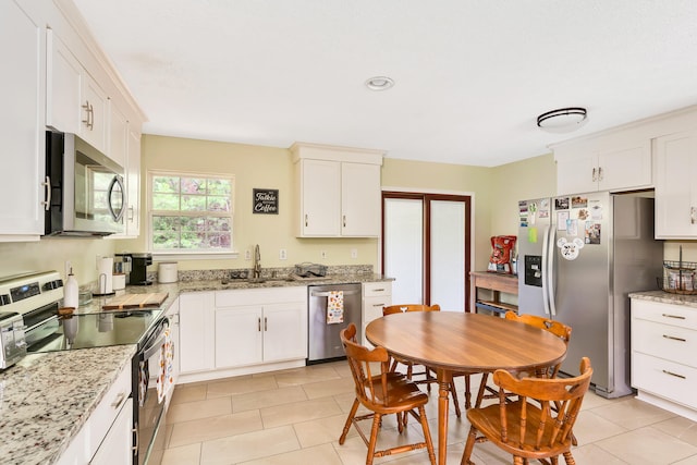 kitchen featuring stainless steel appliances, sink, light stone countertops, and white cabinetry