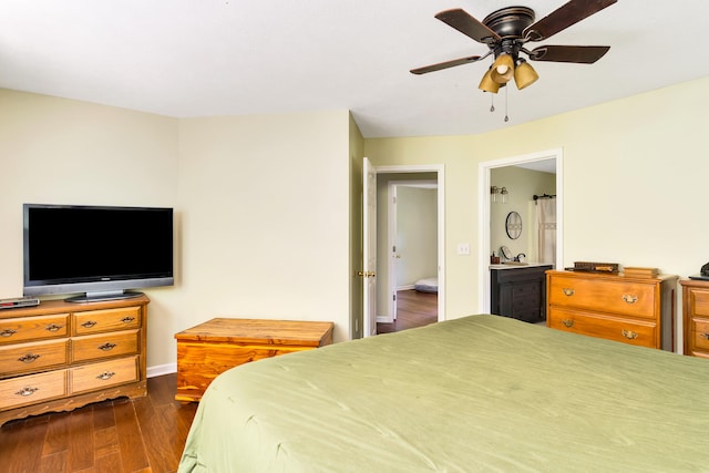 bedroom with dark wood-type flooring, ceiling fan, connected bathroom, and sink