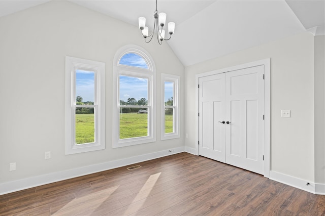 foyer featuring dark wood-type flooring, vaulted ceiling, and a notable chandelier