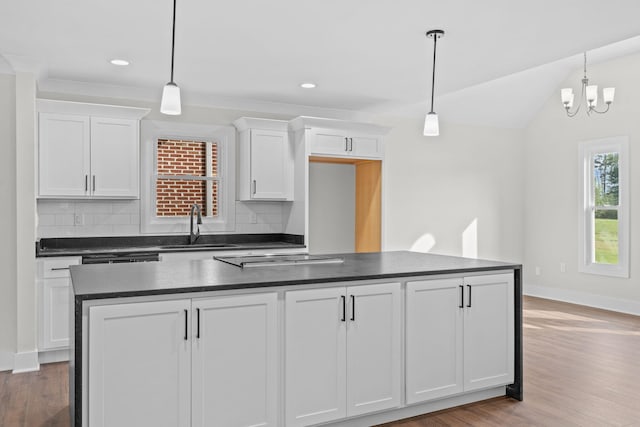 kitchen with a notable chandelier, light hardwood / wood-style flooring, decorative backsplash, and hanging light fixtures