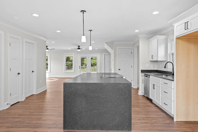 kitchen with white cabinets, stainless steel dishwasher, ceiling fan, and dark hardwood / wood-style floors