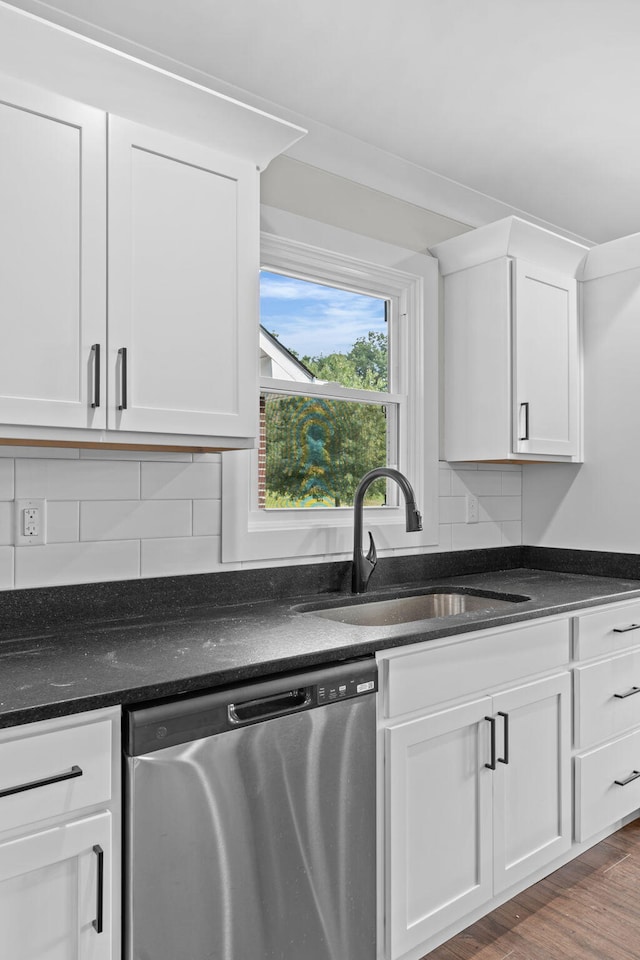 kitchen featuring dishwasher, wood-type flooring, tasteful backsplash, sink, and white cabinetry