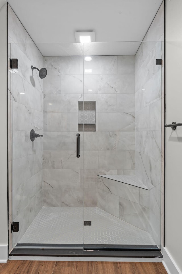 bathroom with hardwood / wood-style floors and an enclosed shower