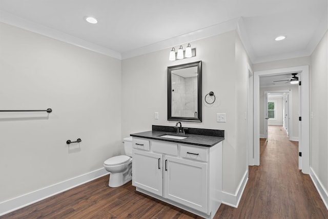 bathroom with ornamental molding, vanity, hardwood / wood-style flooring, and ceiling fan