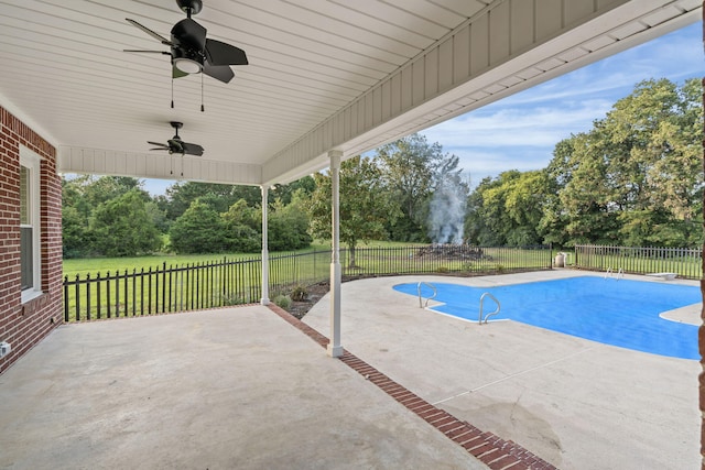 view of swimming pool with a yard, ceiling fan, and a patio area