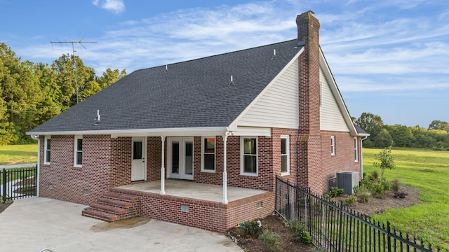 back of house with cooling unit, a lawn, and a patio area