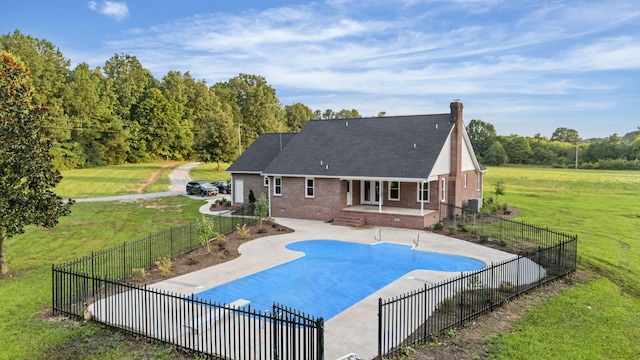 view of pool featuring a yard, central AC unit, and a patio area