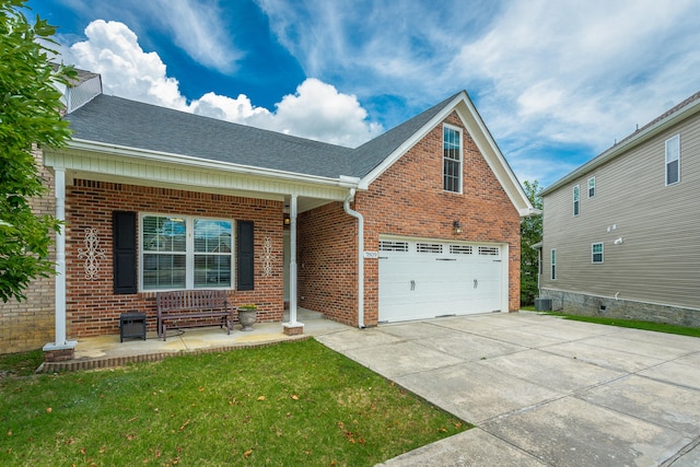 view of front of property featuring a garage, a front yard, and central AC unit